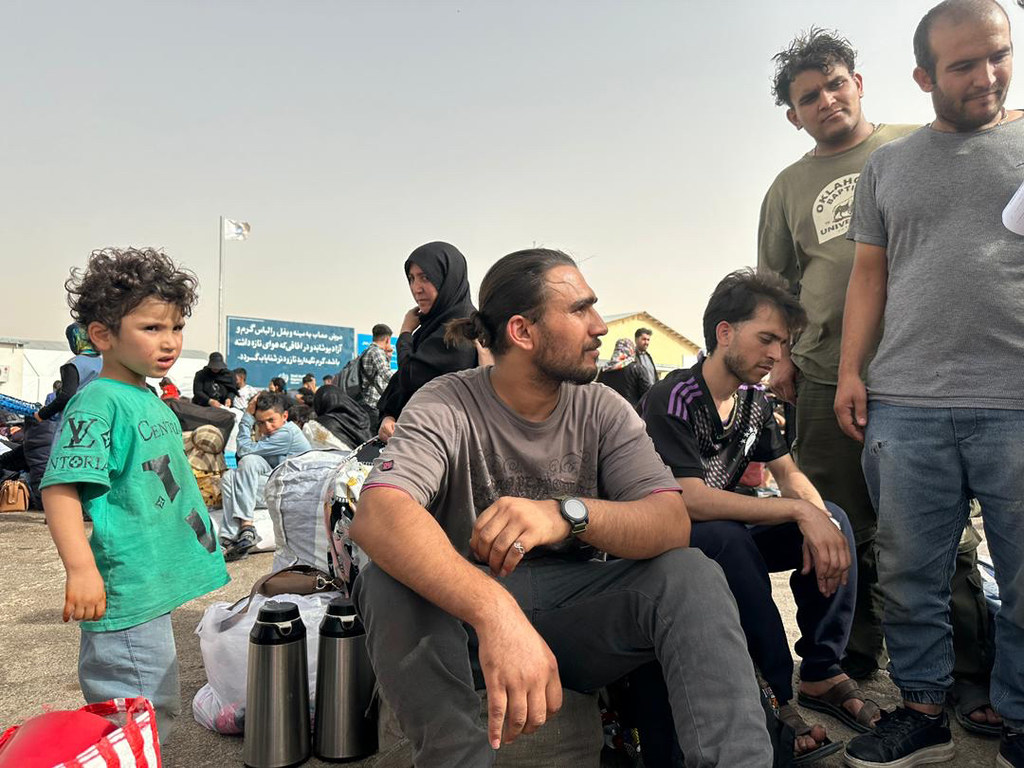 Des Afghans récemment arrivés d'Iran se rassemblent au poste frontière d'Islam Qala.